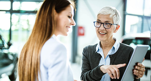 Beraterin zeigt Kundin die Optionen im Rahmen des Flottenaustauschprogramms im Kontext von Sozial & Mobil