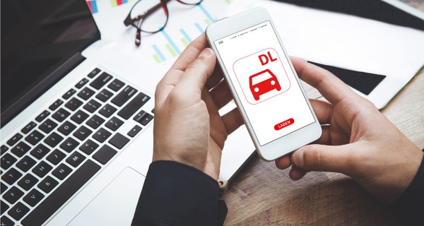 Person h&auml;lt ein Smartphone mit der Deutsche Leasing Mobility App in der Hand 